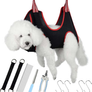 A white poodle in a Pet Grooming Harness Hammock with grooming supplies.